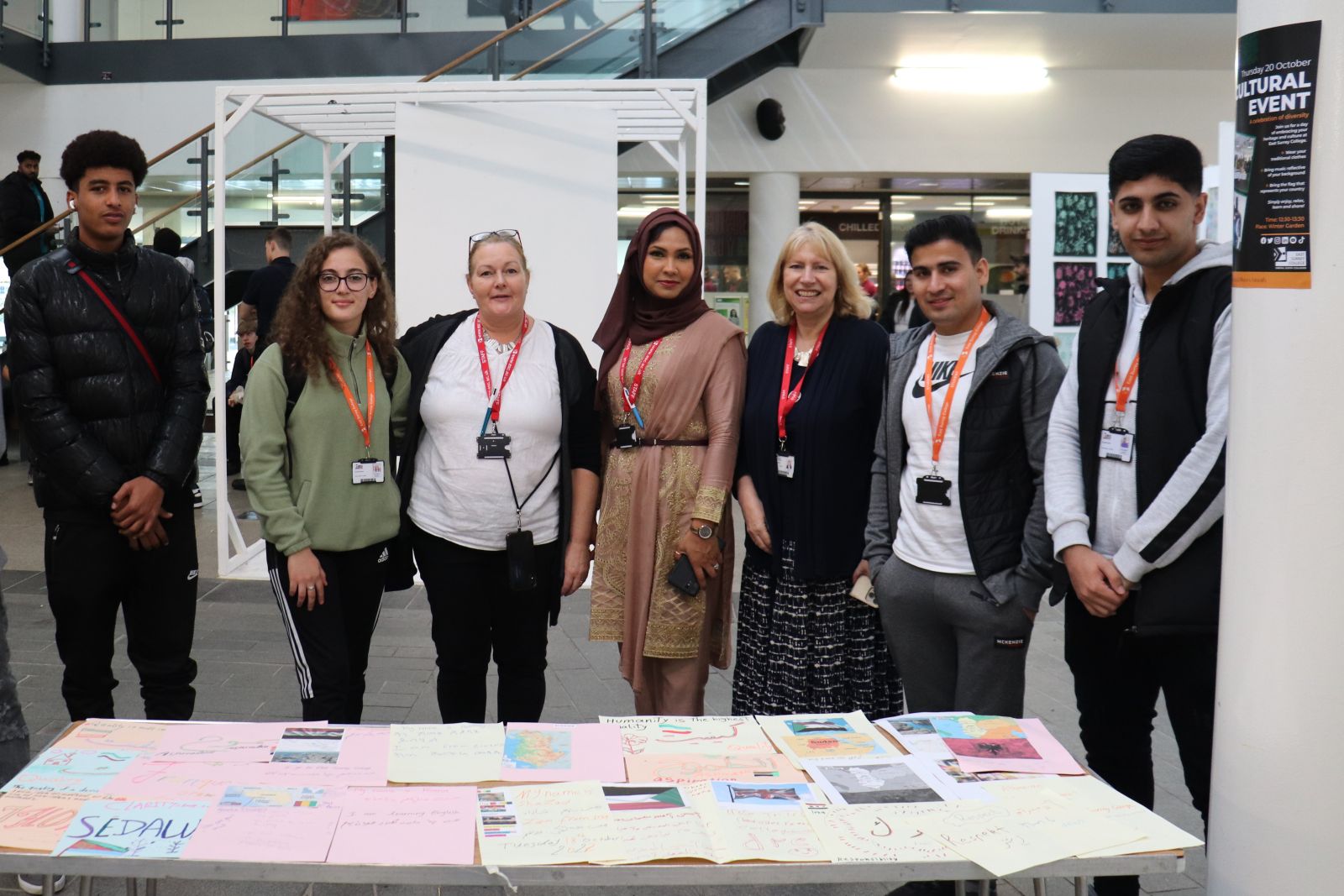 Students and staff behind a table of work relating to their country of origin
