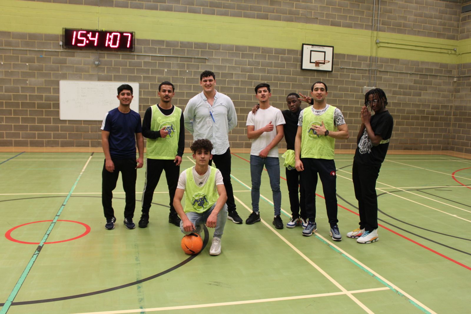 A group of students looking at the camera with a basketball