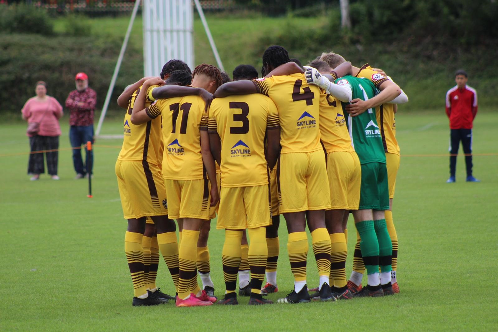 Football players in yellow shirts in a huddle