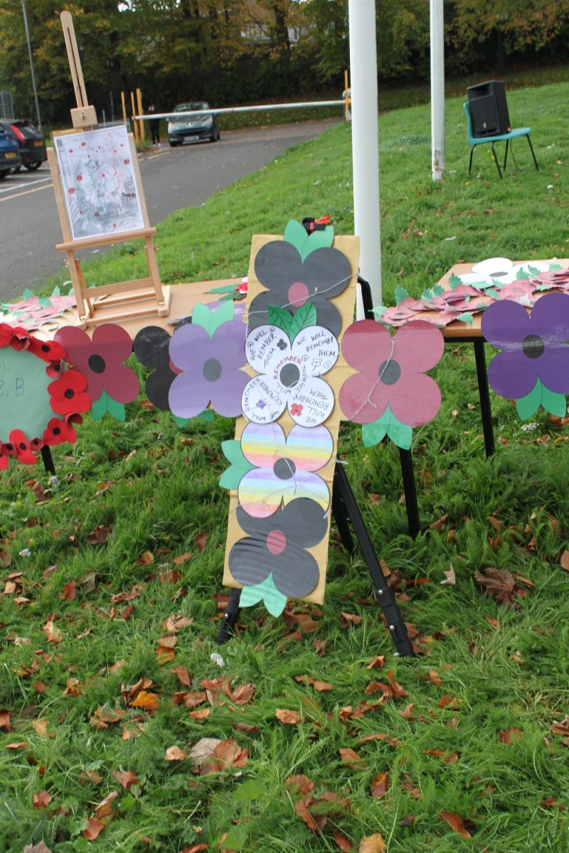A large cross with handmade poppied attached to it